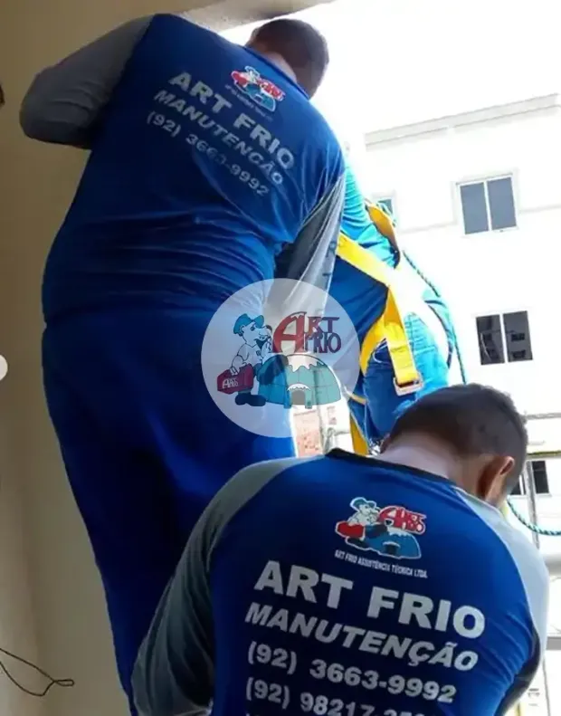Dupla de técnicos da Art Frio trabalhando em altura com cinto de segurança